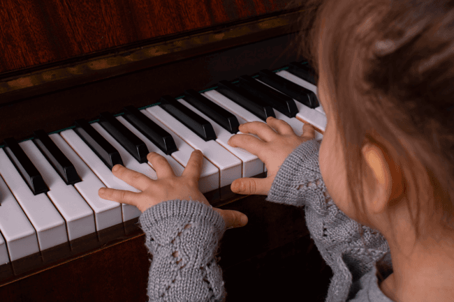 Child learning to play piano